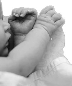 a black and white photo of a baby's hand on top of its head