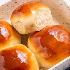 three rolls in a white bowl on a table