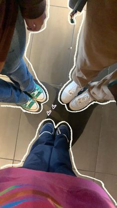 three people standing in a circle with their feet up on the floor and looking down at them