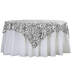 a table with sequins on it and a white table cloth over the top