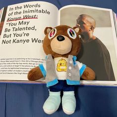 a teddy bear is sitting in front of an open book, with the image of a man on it