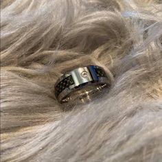 a wedding ring is laying on top of some fur, and it looks to be in the middle of someone's hair