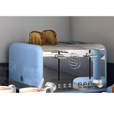 a toaster with two slices of bread sitting on top of it next to coffee mugs