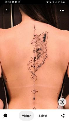 the back of a woman's neck with an arrow and fox tattoo on it