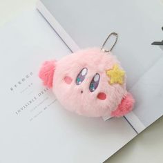 a pink stuffed animal keychain with a star on it's head and eyes