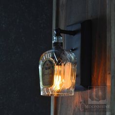 a light that is on the side of a wall next to a glass bottle in front of a door