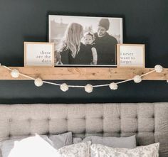 a bed with two pictures on the wall above it and a string of lights hanging from the headboard