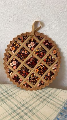 a pie with flowers on it sitting on top of a table next to a pillow