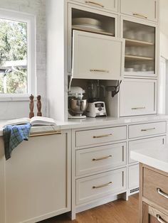 a kitchen with white cabinets and wooden floors