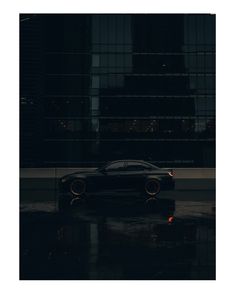 a car parked in front of a tall building at night