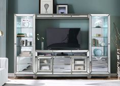 a living room with a large tv on top of a entertainment center next to a white couch