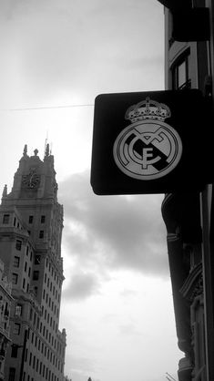 a black and white photo of the real madrid football club logo on a street sign