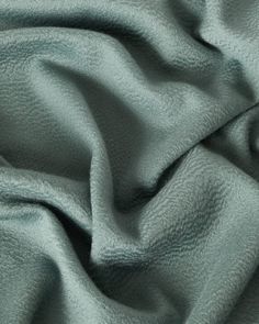 a close up view of a green fabric with very soft folds on it's surface