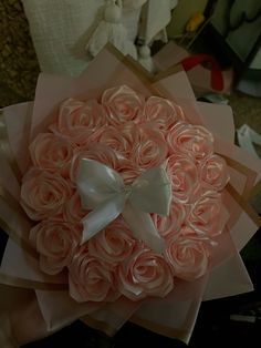 a bouquet of pink roses with a white bow