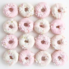 pink and white donuts with sprinkles arranged in the shape of hearts