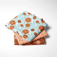 three folded napkins sitting on top of each other in different colors and designs,