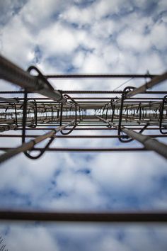 an overhead view of wires and sky with clouds in the backgroung, taken from below