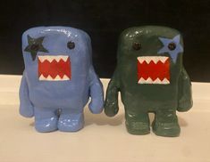 two plastic monsters are standing next to each other