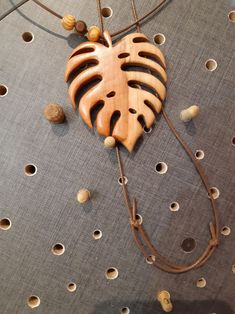 a wooden heart hanging from a string on top of a table with holes in it