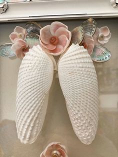 two seashells with pink flowers are on display