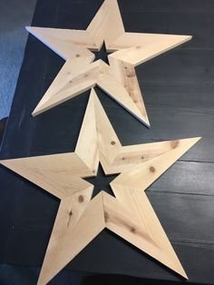 three wooden stars sitting on top of a black table