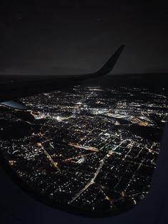 the view from an airplane window at night, looking down on a cityscape