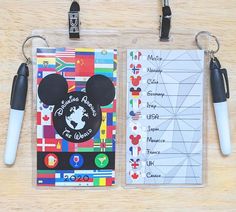 the mickey mouse passport is next to two pens and a clipboard with an id card attached