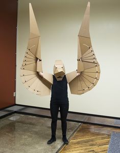 a woman holding an umbrella made out of cardboard