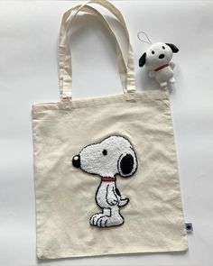 a white bag with a dog on it next to a stuffed animal