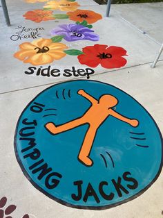 the sidewalk is decorated with colorful flowers and an image of a jumping jack's sign