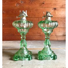 two green glass candlesticks sitting next to each other