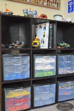 a bookcase filled with lots of plastic containers on top of carpeted flooring