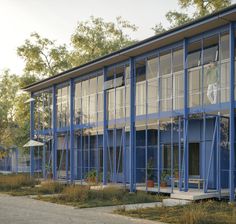 a blue building with lots of windows next to trees