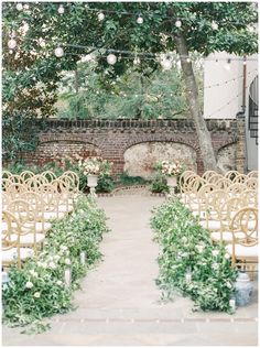 an outdoor ceremony set up with gold chairs and greenery