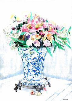 a blue and white vase filled with lots of flowers