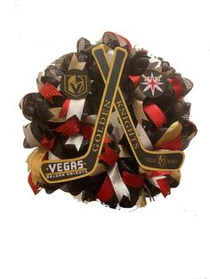 the vegas knights hockey wreath is decorated with black, red and gold ribbons that are attached to each other