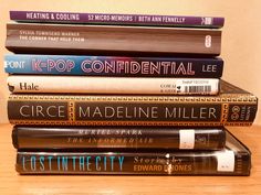 a stack of books sitting on top of a wooden table