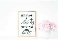 a white vase with pink flowers next to a framed print that says, let's take a dot she's tying the knot