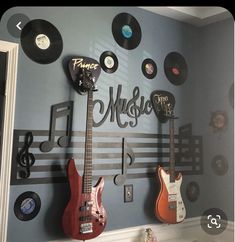 there are many guitars and music notes on the wall in this room with blue walls