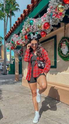 a woman is posing for the camera in front of a building with christmas decorations on it