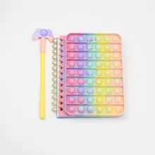 a rainbow colored notebook with a pencil and eraser next to it