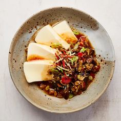 a white bowl filled with food on top of a table