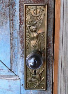 an ornate door handle with a keyhole and angel design on the front of a wooden door