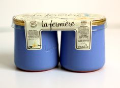 two blue jars with labels on them sitting next to each other