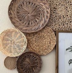 wicker baskets are hanging on the wall next to a framed photograph and an art print