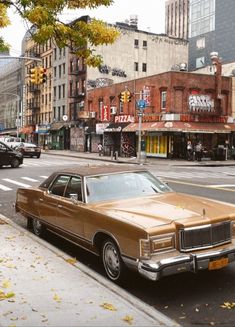 an old car is parked on the side of the street