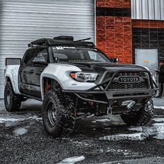 a white toyota truck parked in front of a building