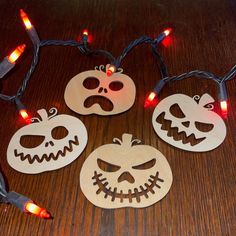 four wooden jack - o - lanterns with lights on them