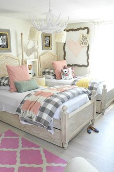 a bed room with two beds and a pink rug