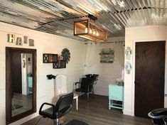 a hair salon with chairs, mirrors and lights on the ceiling in front of it